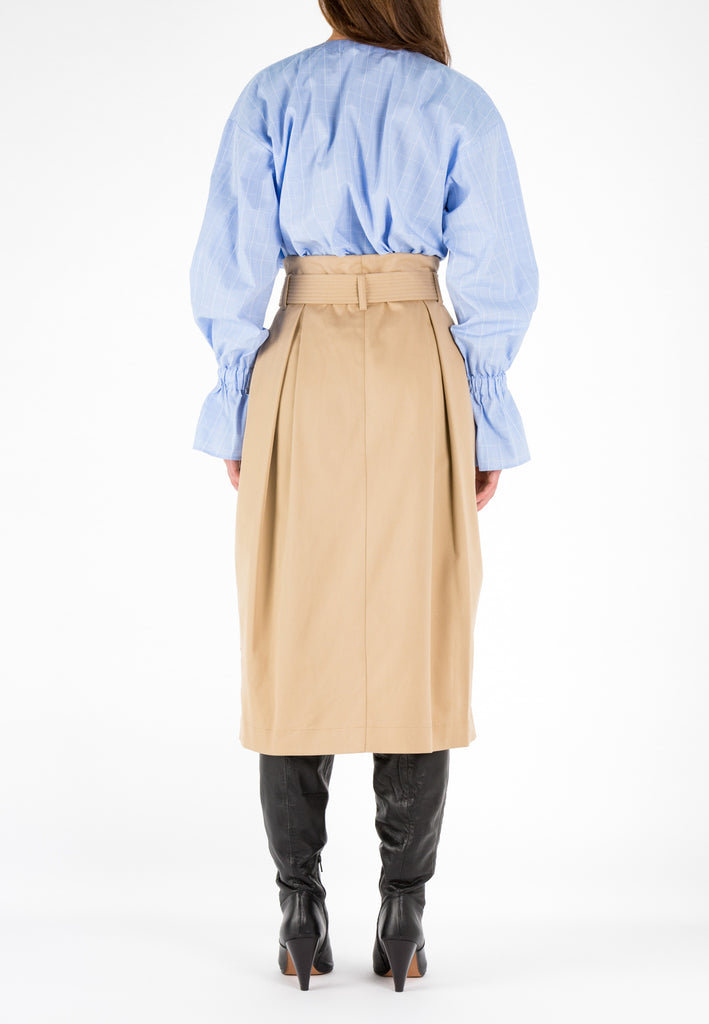 Camel skirt with belt. A sculptural midi skirt in heavy cotton. With two pleats at the front and at the back. A long double stitched belt. This classic camel is easy to combine. Model wears a size 36.