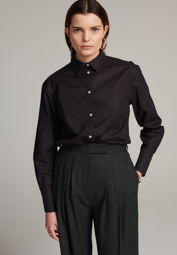 FRENKEN cotton poplin shirt with classic stand collar and button fly-front in choco color. Specially detailed at the back yoke, with the two pannels being joint by a self-fabric string that leaves an elegant cut-out.