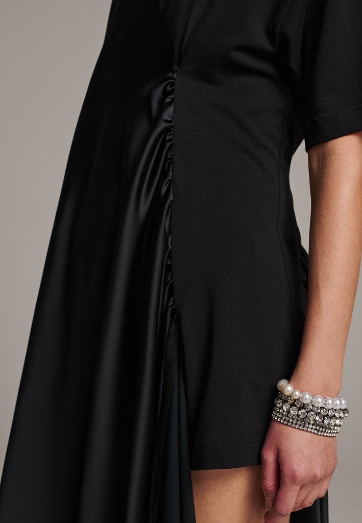 Elevate your wardrobe with this deconstructed dress. Features a v-neckline, dropped shoulders, and an asymmetric detail.