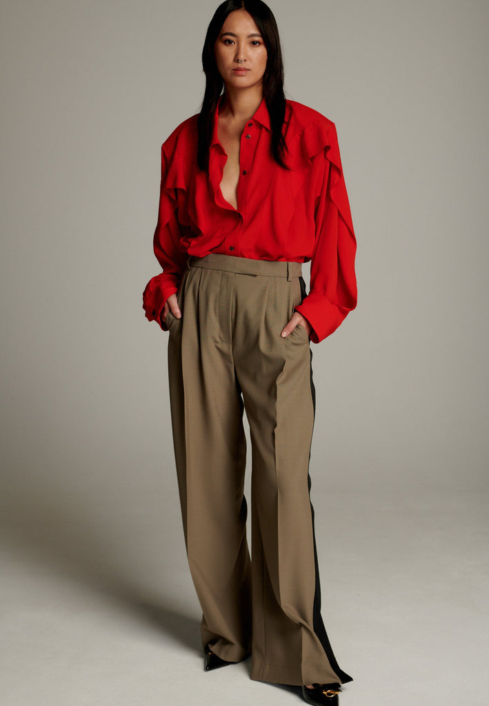 Crepe Georgette shirt with classic red collar. It has black six-hole buttons to adjust the neckline. Special detail with a panel of frills that creates a voluminous look to the garment. This style goes well with jeans and tailoring.