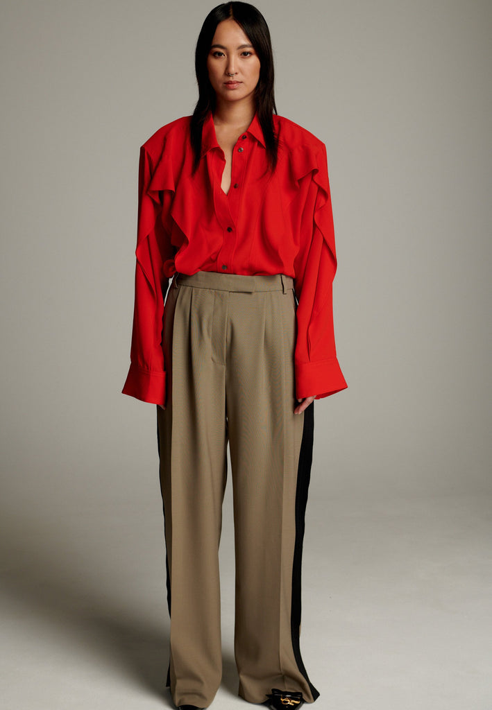 Crepe Georgette shirt with classic red collar. It has black six-hole buttons to adjust the neckline. Special detail with a panel of frills that creates a voluminous look to the garment. This style goes well with jeans and tailoring.