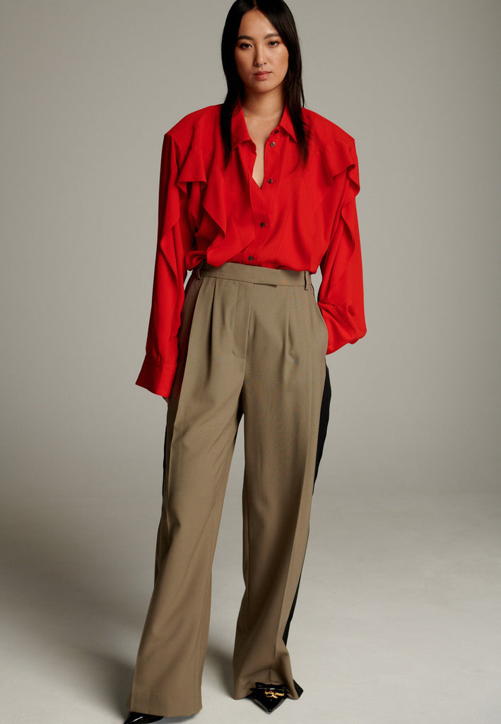Crepe Georgette shirt with classic red collar. It has black six-hole buttons to adjust the neckline. Special detail with a panel of frills that creates a voluminous look to the garment. This style goes well with jeans and tailoring.