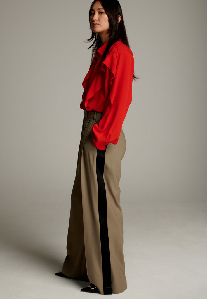Crepe Georgette shirt with classic red collar. It has black six-hole buttons to adjust the neckline. Special detail with a panel of frills that creates a voluminous look to the garment. This style goes well with jeans and tailoring.