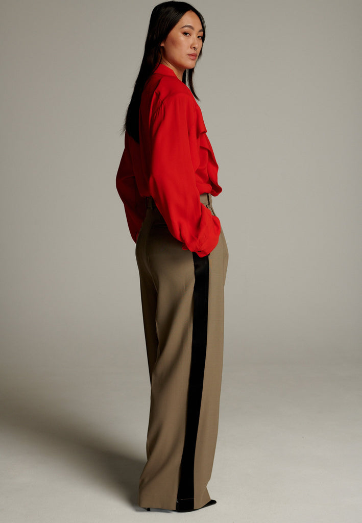 Crepe Georgette shirt with classic red collar. It has black six-hole buttons to adjust the neckline. Special detail with a panel of frills that creates a voluminous look to the garment. This style goes well with jeans and tailoring.