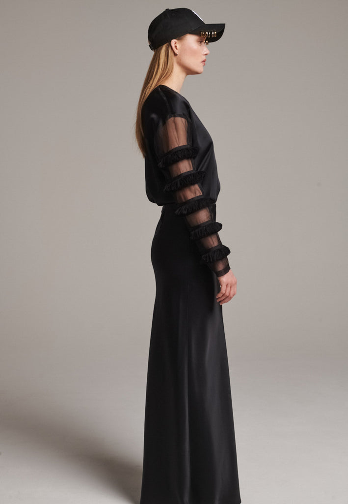 Flowy black skirt with a refined, elongated silhouette. Crafted from lightweight fabric with soft movement and an elegant drape. Front and back darts are intentionally exposed, adding subtle structure and a tailored finish to the fluid shape. A quiet statement piece, effortlessly balancing form and flow.