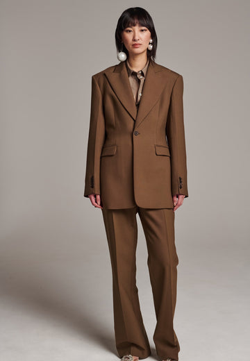 Experience flawless tailoring with this structured blazer, featuring sharp wide shoulders and a subtly cinched waist. Fully satin-lined for added luxury, it includes horn buttons and welt pockets with flaps, along with a back slit for ease of movement. Masterfully crafted in a versatile camel hue, this blazer seamlessly complements a range of colors, embodying precision and elegance.