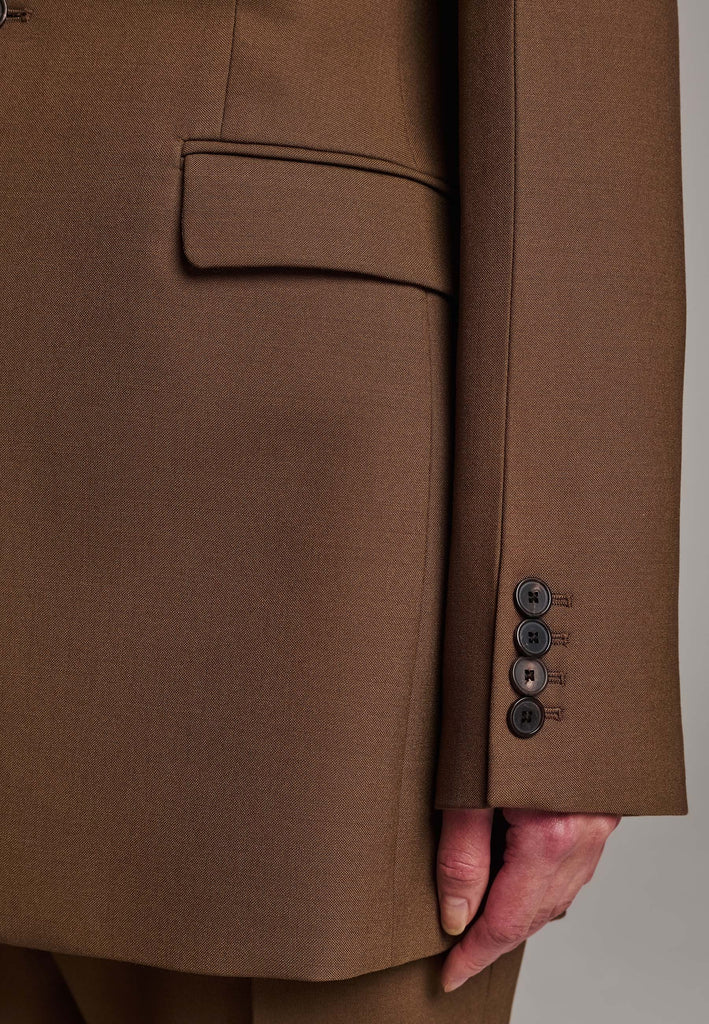 Experience flawless tailoring with this structured blazer, featuring sharp wide shoulders and a subtly cinched waist. Fully satin-lined for added luxury, it includes horn buttons and welt pockets with flaps, along with a back slit for ease of movement. Masterfully crafted in a versatile camel hue, this blazer seamlessly complements a range of colors, embodying precision and elegance.