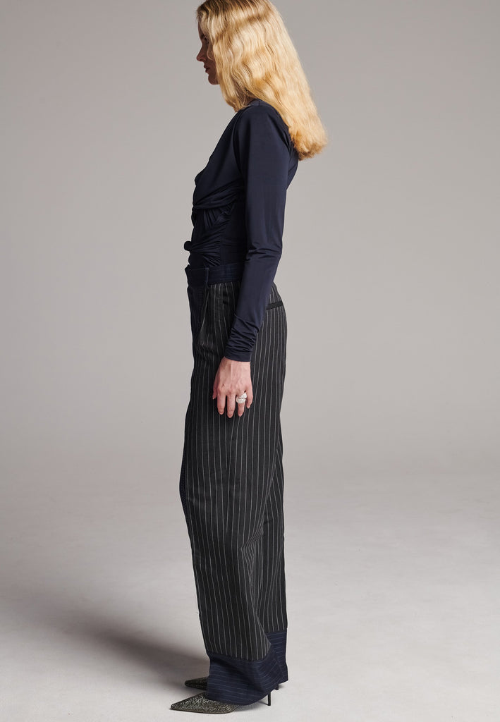 Long wide-leg trousers cut from two faintly pinstriped linen blends. Detailed with welt pockets and button closure.