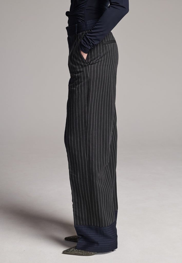 Long wide-leg trousers cut from two faintly pinstriped linen blends. Detailed with welt pockets and button closure.