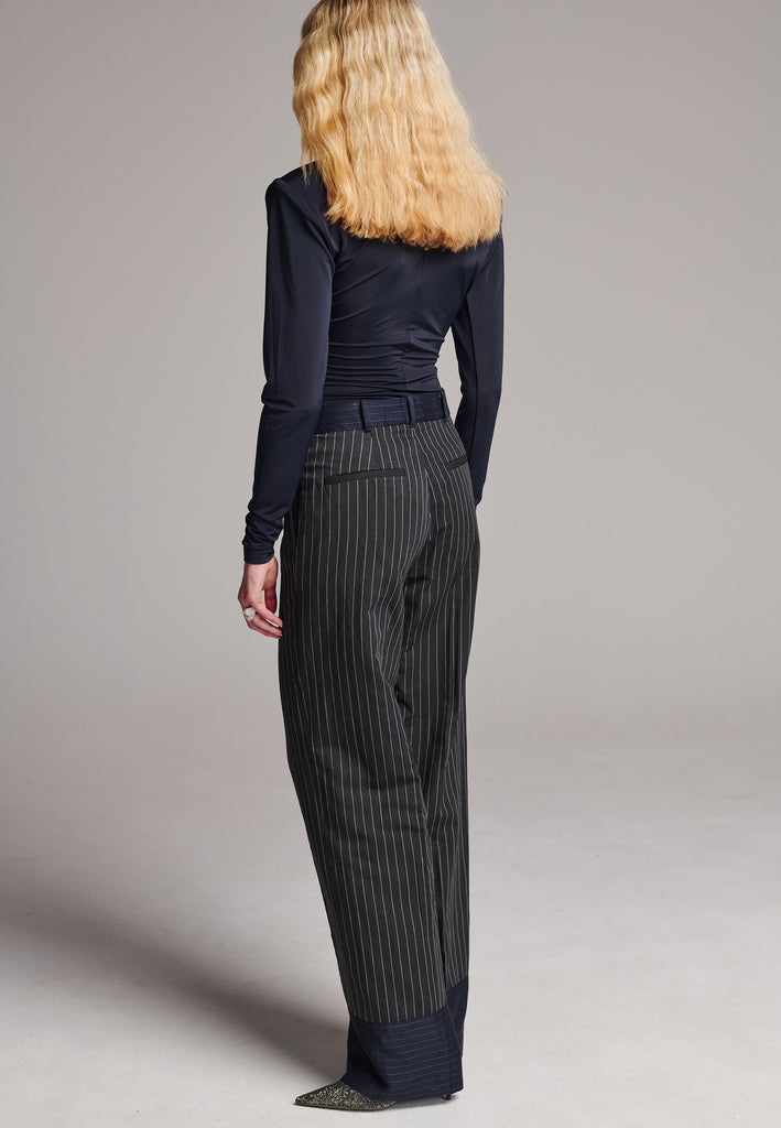 Long wide-leg trousers cut from two faintly pinstriped linen blends. Detailed with welt pockets and button closure.