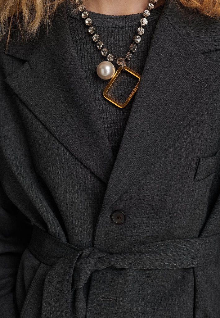 Oversized wrap blazer cut from a wool blend. Designed for an oversized fit, cut to be worn very loose. Padded wide round shoulders that add structure to the loose fit. Knot the inserted belt at the back or front to customize the shape. Horn button closure, welt pocket at front. Central vent at back hem. Full viscose satin lining and detailed with a needlepoint on the belt. This longline silhouette is perfectly tailored and could be your everyday rotation blazer.