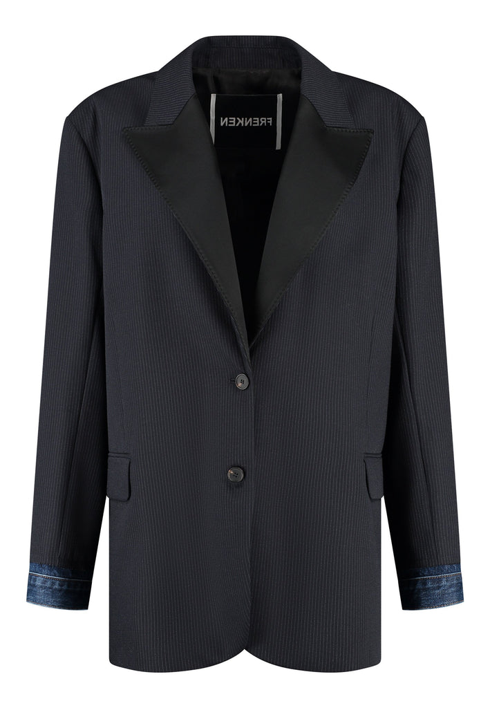The Devotion Pinstripe Blazer Navy is a bold, reimagined take on classic tailoring. Designed with an oversized silhouette, it features a timeless navy pinstripe base contrasted by sleek black lapels in a subtly glossy fabric, adding a refined, modern twist. The cuffs break convention with a denim finish, introducing a casual edge to the otherwise structured piece. 