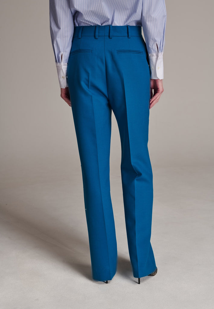 Discover unparalleled elegance with this structured bell-cut, perfectly tailored pant, adorned with striking Swarovski crystals that appear to be artfully scattered across the front. Designed by Frenken, this piece offers a slightly oversized fit, embodying a refined yet contemporary silhouette. Inspired by menswear, these trousers effortlessly blend sharp tailoring with a touch of glamour, ensuring a perfect fit and a standout addition to your wardrobe.