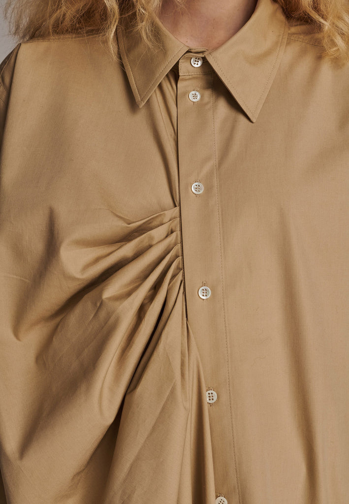 Oversized asymmetric shirt. Specially detailed with a long ruffle effect on one side. It has a button closure to adjust the neckline. 100% Cotton and with an oversized loose shape. Designed for a comfortable and unique fit. A timeless piece.