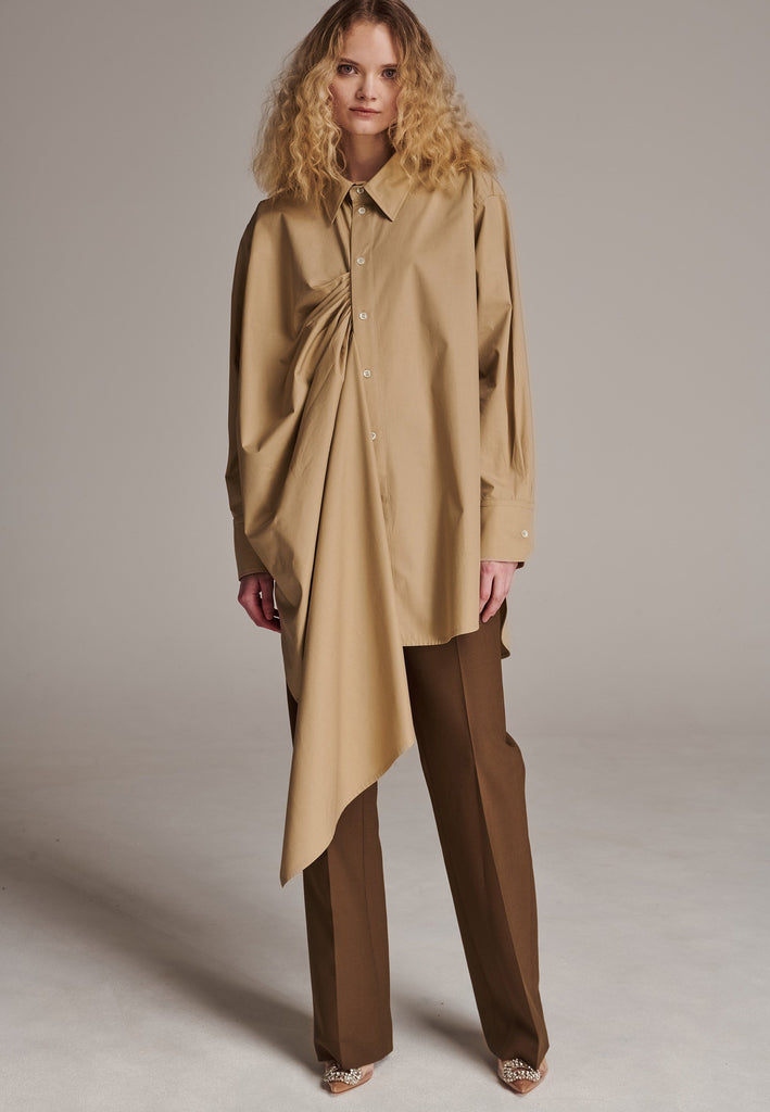 Oversized asymmetric shirt. Specially detailed with a long ruffle effect on one side. It has a button closure to adjust the neckline. 100% Cotton and with an oversized loose shape. Designed for a comfortable and unique fit. A timeless piece.