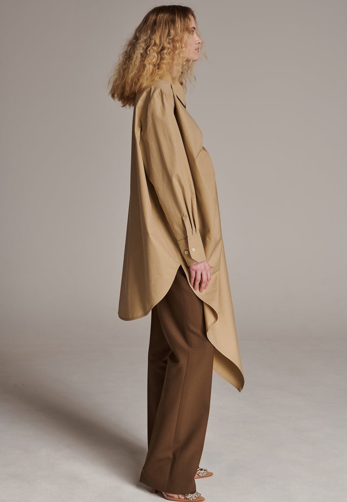 Oversized asymmetric shirt. Specially detailed with a long ruffle effect on one side. It has a button closure to adjust the neckline. 100% Cotton and with an oversized loose shape. Designed for a comfortable and unique fit. A timeless piece.