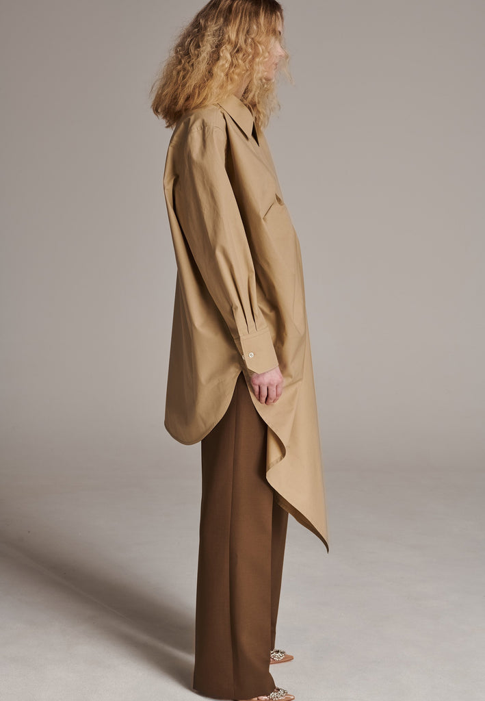 Oversized asymmetric shirt. Specially detailed with a long ruffle effect on one side. It has a button closure to adjust the neckline. 100% Cotton and with an oversized loose shape. Designed for a comfortable and unique fit. A timeless piece.