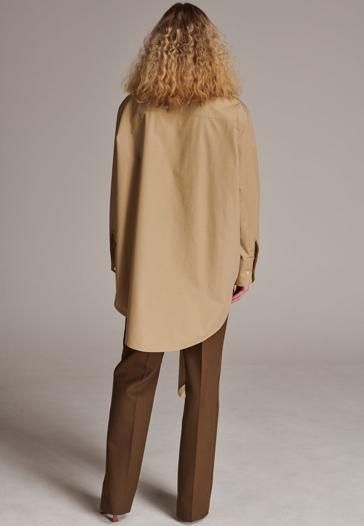 Oversized asymmetric shirt. Specially detailed with a long ruffle effect on one side. It has a button closure to adjust the neckline. 100% Cotton and with an oversized loose shape. Designed for a comfortable and unique fit. A timeless piece.