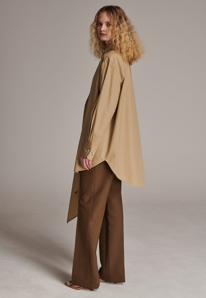 Oversized asymmetric shirt. Specially detailed with a long ruffle effect on one side. It has a button closure to adjust the neckline. 100% Cotton and with an oversized loose shape. Designed for a comfortable and unique fit. A timeless piece.