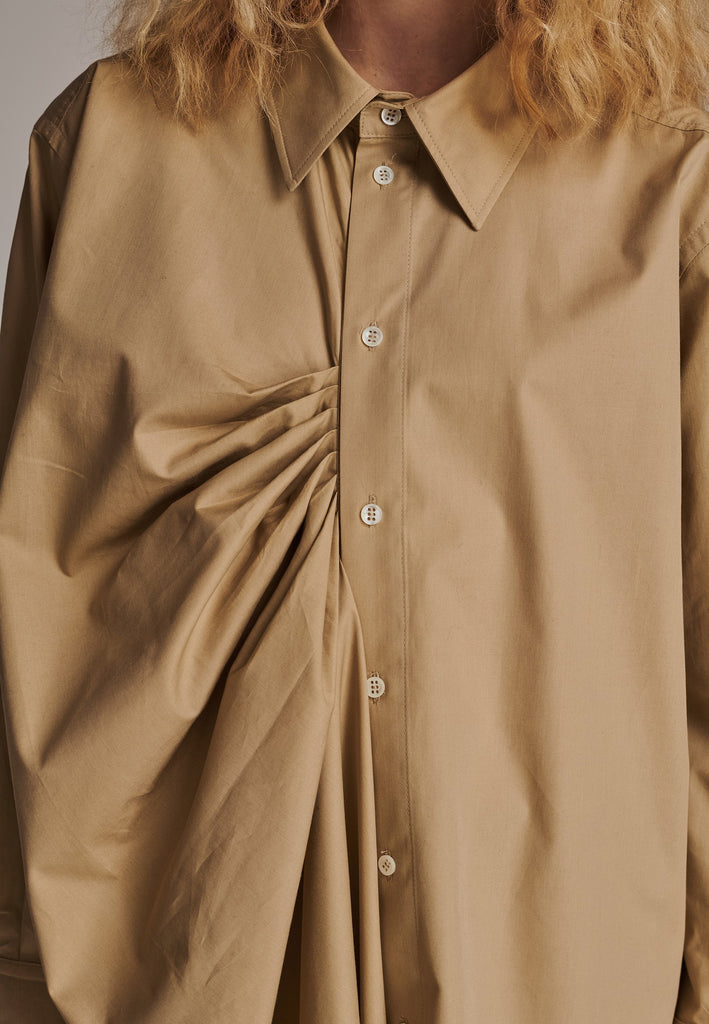 Oversized asymmetric shirt. Specially detailed with a long ruffle effect on one side. It has a button closure to adjust the neckline. 100% Cotton and with an oversized loose shape. Designed for a comfortable and unique fit. A timeless piece.