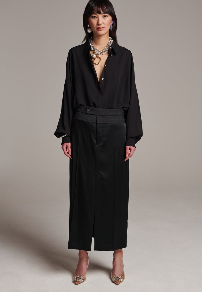 As the core of Frenken is menswear tailoring it all comes together in this designer piece. Erik Frenken started with menswear pants upper part in wool with a horn button. Cut it and elevate and contrast it with a glossy satin crepe. This midi skirt is detailed with a slit at the front, raw edge and pockets. Designed to sit on the waist, they're made from glossy satin stretch crepe for comfortable wear. Wear them with the matching MORTER top or our big-knit PRECIOUS and tonal blazers.