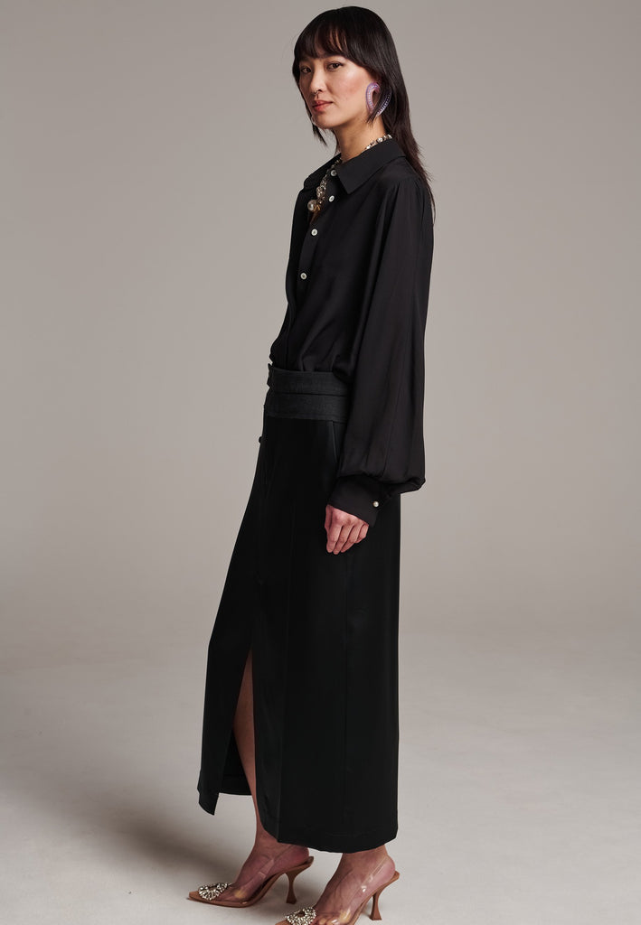 As the core of Frenken is menswear tailoring it all comes together in this designer piece. Erik Frenken started with menswear pants upper part in wool with a horn button. Cut it and elevate and contrast it with a glossy satin crepe. This midi skirt is detailed with a slit at the front, raw edge and pockets. Designed to sit on the waist, they're made from glossy satin stretch crepe for comfortable wear. Wear them with the matching MORTER top or our big-knit PRECIOUS and tonal blazers.