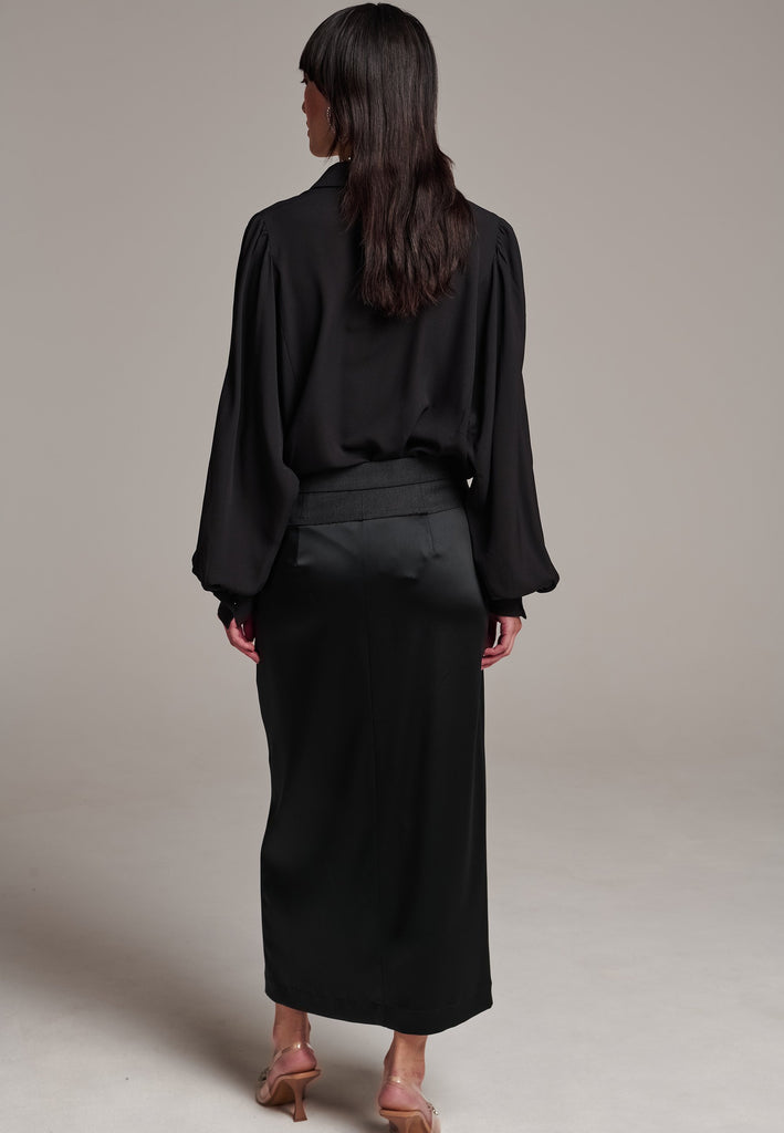 As the core of Frenken is menswear tailoring it all comes together in this designer piece. Erik Frenken started with menswear pants upper part in wool with a horn button. Cut it and elevate and contrast it with a glossy satin crepe. This midi skirt is detailed with a slit at the front, raw edge and pockets. Designed to sit on the waist, they're made from glossy satin stretch crepe for comfortable wear. Wear them with the matching MORTER top or our big-knit PRECIOUS and tonal blazers.
