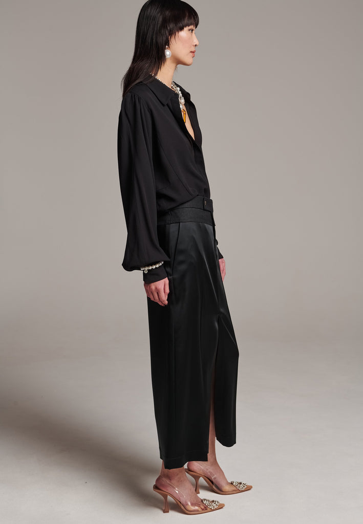 As the core of Frenken is menswear tailoring it all comes together in this designer piece. Erik Frenken started with menswear pants upper part in wool with a horn button. Cut it and elevate and contrast it with a glossy satin crepe. This midi skirt is detailed with a slit at the front, raw edge and pockets. Designed to sit on the waist, they're made from glossy satin stretch crepe for comfortable wear. Wear them with the matching MORTER top or our big-knit PRECIOUS and tonal blazers.