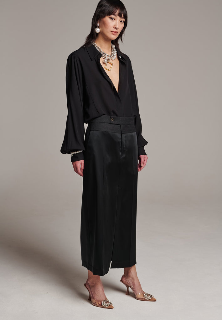 As the core of Frenken is menswear tailoring it all comes together in this designer piece. Erik Frenken started with menswear pants upper part in wool with a horn button. Cut it and elevate and contrast it with a glossy satin crepe. This midi skirt is detailed with a slit at the front, raw edge and pockets. Designed to sit on the waist, they're made from glossy satin stretch crepe for comfortable wear. Wear them with the matching MORTER top or our big-knit PRECIOUS and tonal blazers.