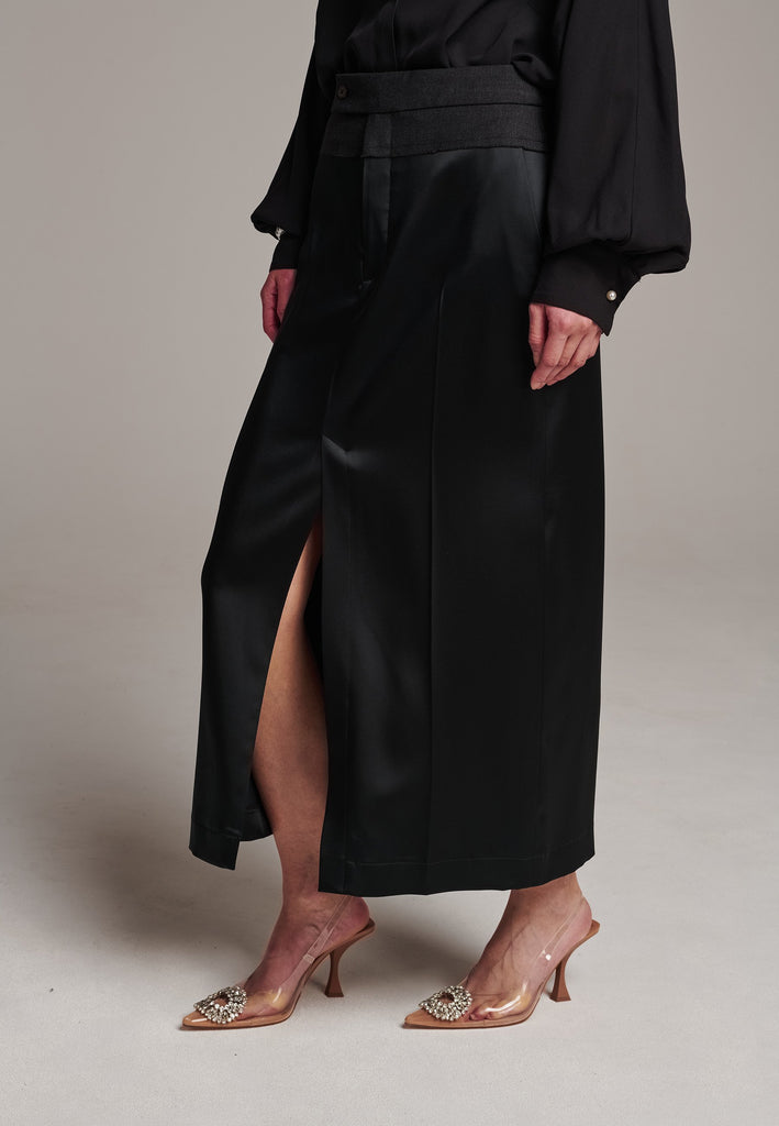As the core of Frenken is menswear tailoring it all comes together in this designer piece. Erik Frenken started with menswear pants upper part in wool with a horn button. Cut it and elevate and contrast it with a glossy satin crepe. This midi skirt is detailed with a slit at the front, raw edge and pockets. Designed to sit on the waist, they're made from glossy satin stretch crepe for comfortable wear. Wear them with the matching MORTER top or our big-knit PRECIOUS and tonal blazers.