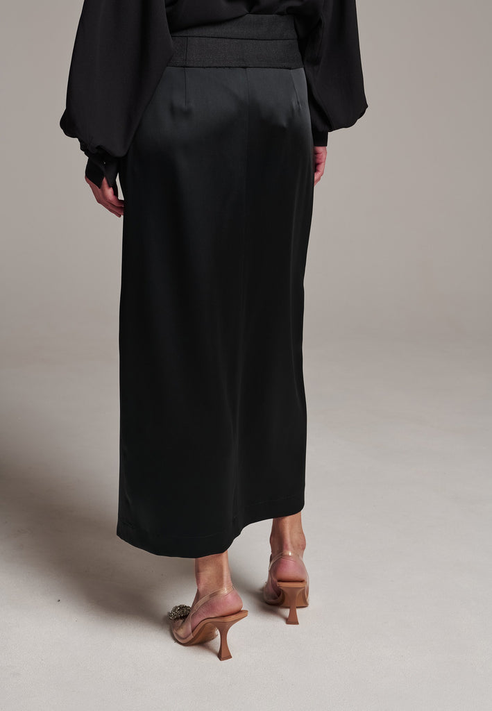 As the core of Frenken is menswear tailoring it all comes together in this designer piece. Erik Frenken started with menswear pants upper part in wool with a horn button. Cut it and elevate and contrast it with a glossy satin crepe. This midi skirt is detailed with a slit at the front, raw edge and pockets. Designed to sit on the waist, they're made from glossy satin stretch crepe for comfortable wear. Wear them with the matching MORTER top or our big-knit PRECIOUS and tonal blazers.