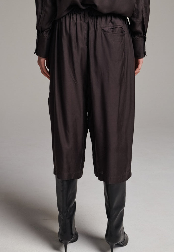 These Found Silk Dark Brown Habotai Pants offer a luxurious, relaxed look with a cropped design that falls just below the knee. Crafted from soft, lightweight silk habotai, they provide a smooth, fluid drape with a subtle sheen. The rich dark brown color adds a touch of sophistication, while the comfortable, slightly loose fit ensures effortless style. Perfect for both casual and semi-formal occasions, these pants are an elevated option for warm-weather dressing or layering with longer pieces.