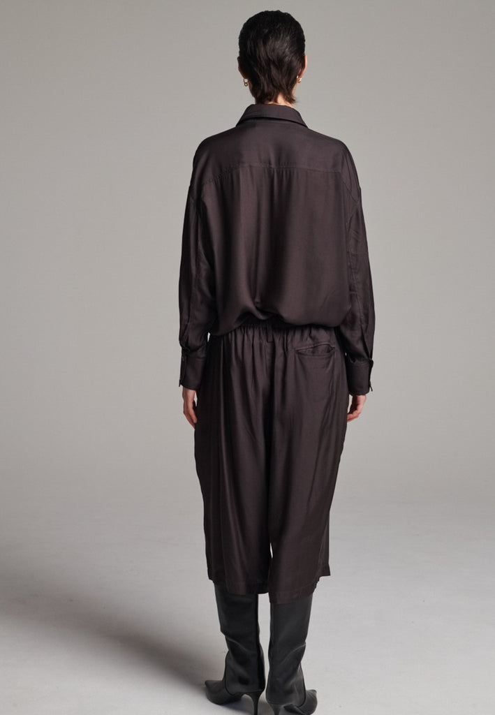 These Found Silk Dark Brown Habotai Pants offer a luxurious, relaxed look with a cropped design that falls just below the knee. Crafted from soft, lightweight silk habotai, they provide a smooth, fluid drape with a subtle sheen. The rich dark brown color adds a touch of sophistication, while the comfortable, slightly loose fit ensures effortless style. Perfect for both casual and semi-formal occasions, these pants are an elevated option for warm-weather dressing or layering with longer pieces.