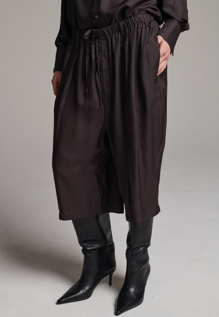 These Found Silk Dark Brown Habotai Pants offer a luxurious, relaxed look with a cropped design that falls just below the knee. Crafted from soft, lightweight silk habotai, they provide a smooth, fluid drape with a subtle sheen. The rich dark brown color adds a touch of sophistication, while the comfortable, slightly loose fit ensures effortless style. Perfect for both casual and semi-formal occasions, these pants are an elevated option for warm-weather dressing or layering with longer pieces.