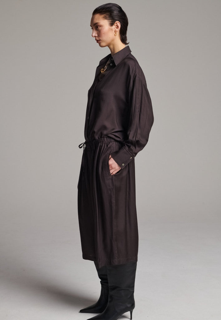 These Found Silk Dark Brown Habotai Pants offer a luxurious, relaxed look with a cropped design that falls just below the knee. Crafted from soft, lightweight silk habotai, they provide a smooth, fluid drape with a subtle sheen. The rich dark brown color adds a touch of sophistication, while the comfortable, slightly loose fit ensures effortless style. Perfect for both casual and semi-formal occasions, these pants are an elevated option for warm-weather dressing or layering with longer pieces.