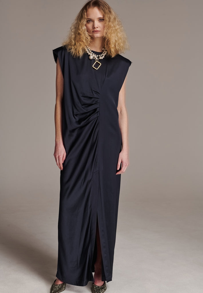 FRENKEN'S comfortable stretch-satin maxi dress is draped in a way that feels equally effortless and elegant. Raw-cut edge at the dramatically wide shoulders for a strong silhouette. Particularly long in length. Thoughtfully designed with gathered detailing, it offers a flattering fit that subtly conceals the midsection. Continue the leg-lengthening illusion of the glamorous front high-slit with point-toe pumps. Designed for a draped silhouette, cut to be worn very loose and very oversized. This dress ensure