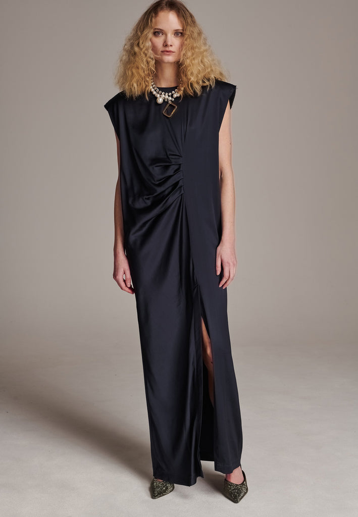 FRENKEN'S comfortable stretch-satin maxi dress is draped in a way that feels equally effortless and elegant. Raw-cut edge at the dramatically wide shoulders for a strong silhouette. Particularly long in length. Thoughtfully designed with gathered detailing, it offers a flattering fit that subtly conceals the midsection. Continue the leg-lengthening illusion of the glamorous front high-slit with point-toe pumps. Designed for a draped silhouette, cut to be worn very loose and very oversized. This dress ensure