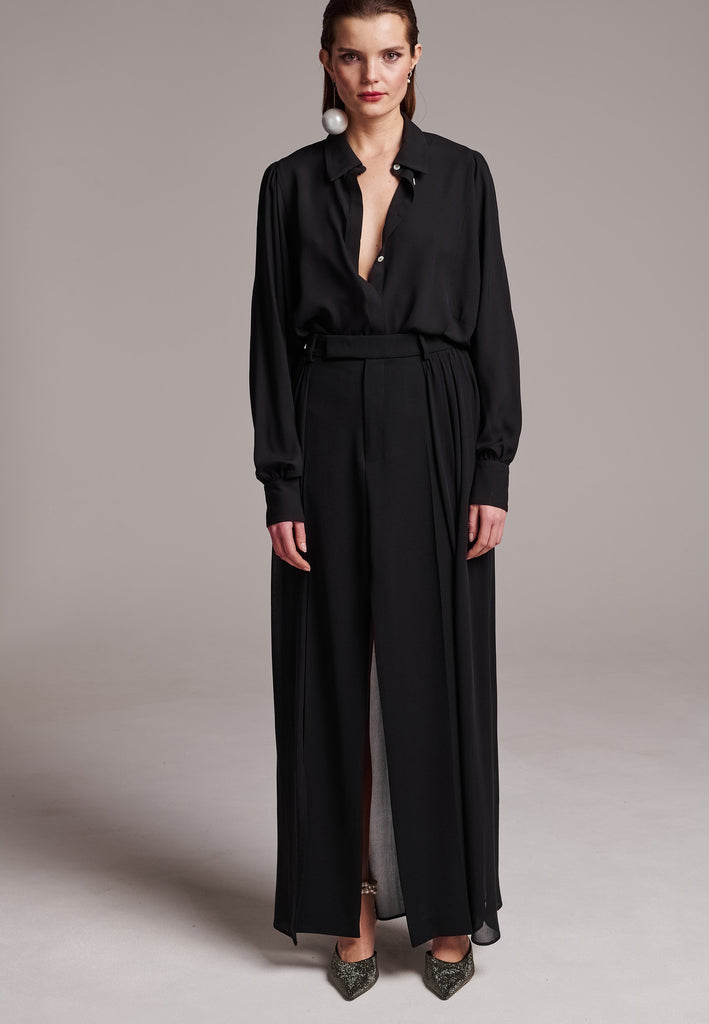 Voluminous poplin shirt with puffed subtle gathered shoulders. Specially detailed with a square armhole seam to create a voluminous sleeve. It has six-hole buttons to adjust the neckline. Cut from 100% silk. Designed for a relaxed fit, cut to be worn very loose. Embellished with a faux pearl on the cuff. This style will go hand in hand with jeans and tailoring.