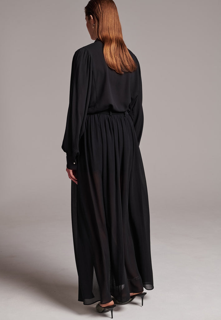 Voluminous poplin shirt with puffed subtle gathered shoulders. Specially detailed with a square armhole seam to create a voluminous sleeve. It has six-hole buttons to adjust the neckline. Cut from 100% silk. Designed for a relaxed fit, cut to be worn very loose. Embellished with a faux pearl on the cuff. This style will go hand in hand with jeans and tailoring.