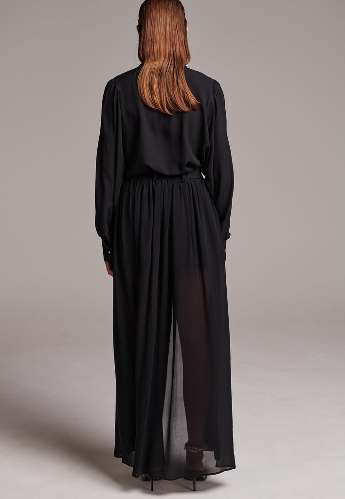 Voluminous poplin shirt with puffed subtle gathered shoulders. Specially detailed with a square armhole seam to create a voluminous sleeve. It has six-hole buttons to adjust the neckline. Cut from 100% silk. Designed for a relaxed fit, cut to be worn very loose. Embellished with a faux pearl on the cuff. This style will go hand in hand with jeans and tailoring.