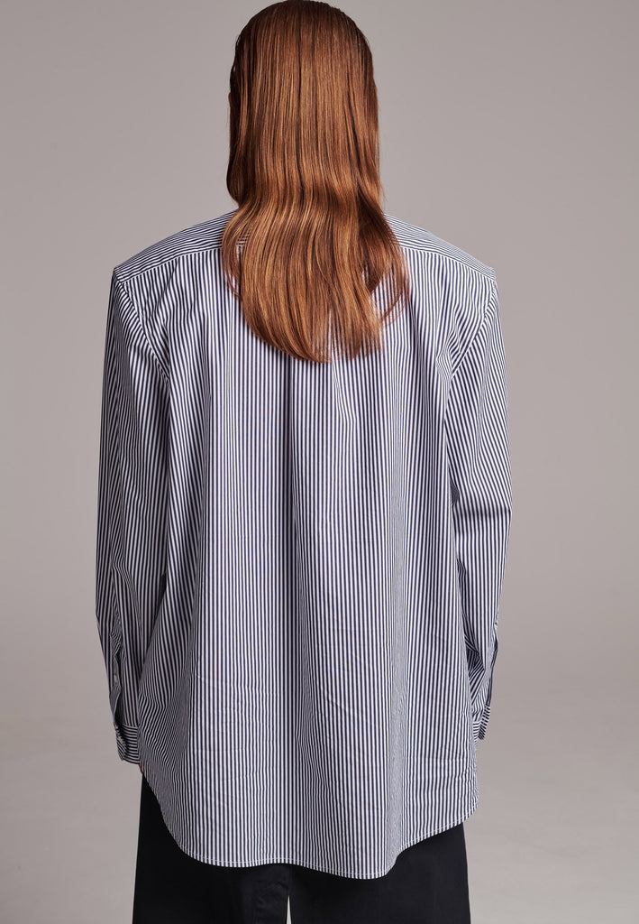 FRENKEN manages to create designs that are somehow classic yet totally modern at the same time. This oversized very easy-to-wear menswear shirt is a true homage to the eighties cut Ralph Lauren men's shirt. Dropped shoulders, with adjustable shoulder pads. Detailed with a mirrored F. Cut from 100% cotton poplin. This Ralf shirt is embellished with faux pearls in an increasing from small to large formation. It's an asset to your wardrobe.