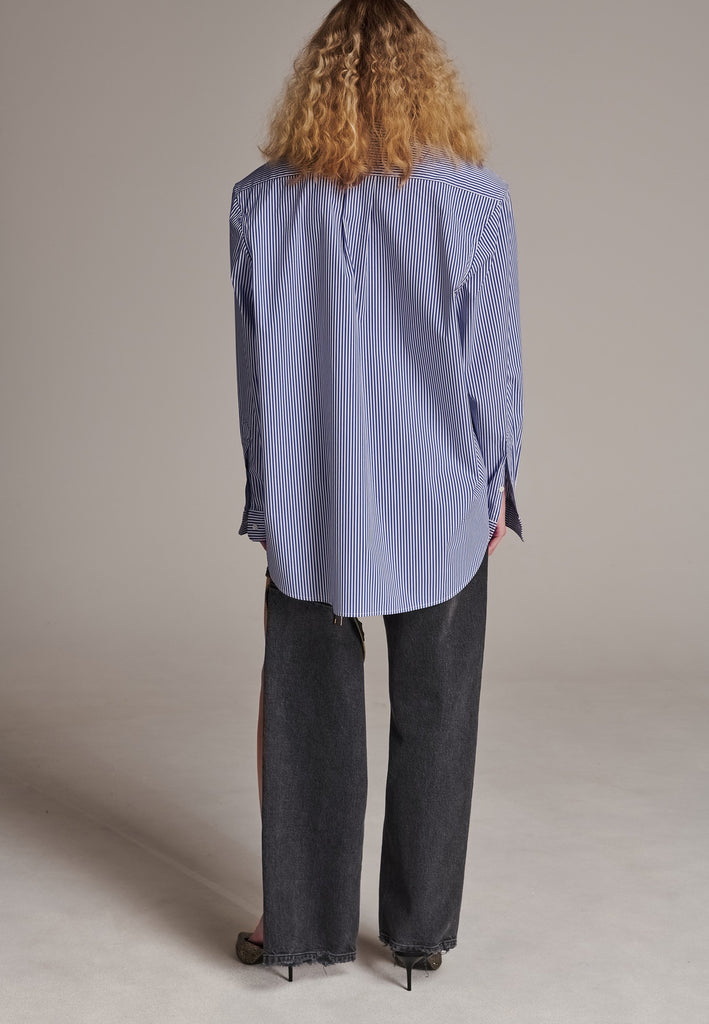 FRENKEN manages to create designs that are somehow classic yet totally modern at the same time. This oversized very easy-to-wear menswear shirt is a true homage to the eighties cut Ralph Lauren men's shirt. Dropped shoulders, with adjustable shoulder pads. Detailed with a mirrored F. Cut from 100% cotton poplin. This Ralf shirt is embellished with faux pearls in an increasing from small to large formation. It's an asset to your wardrobe.