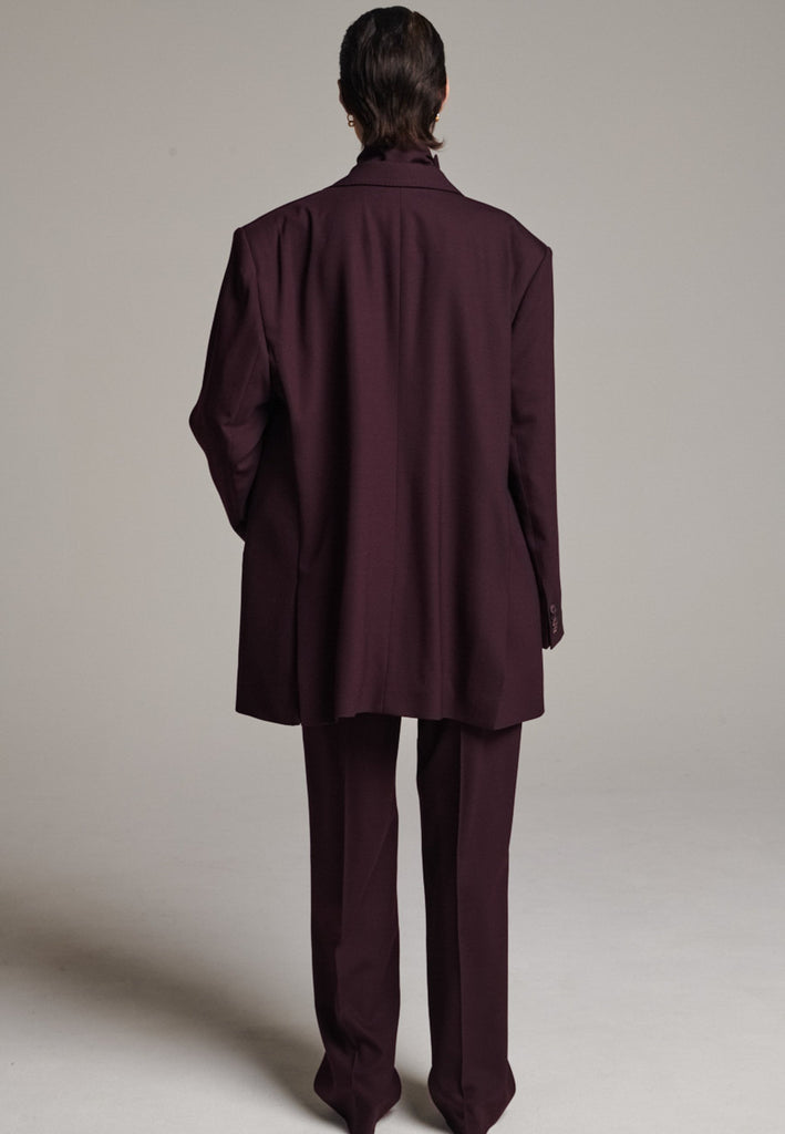 A classic yet oversized blazer, designed to make a bold statement while maintaining timeless appeal. The lower portion of the lapels is crafted from a contrasting shiny fabric, adding an unexpected touch of texture and luxury. The upper part of the collar area is beautifully embellished with gold and silver rings at the tips, offering a refined, modern twist. This piece combines traditional tailoring with avant-garde details, perfect for elevating any outfit with sophistication and edge.
