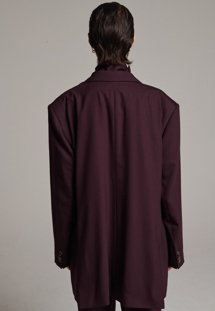 A classic yet oversized blazer, designed to make a bold statement while maintaining timeless appeal. The lower portion of the lapels is crafted from a contrasting shiny fabric, adding an unexpected touch of texture and luxury. The upper part of the collar area is beautifully embellished with gold and silver rings at the tips, offering a refined, modern twist. This piece combines traditional tailoring with avant-garde details, perfect for elevating any outfit with sophistication and edge.