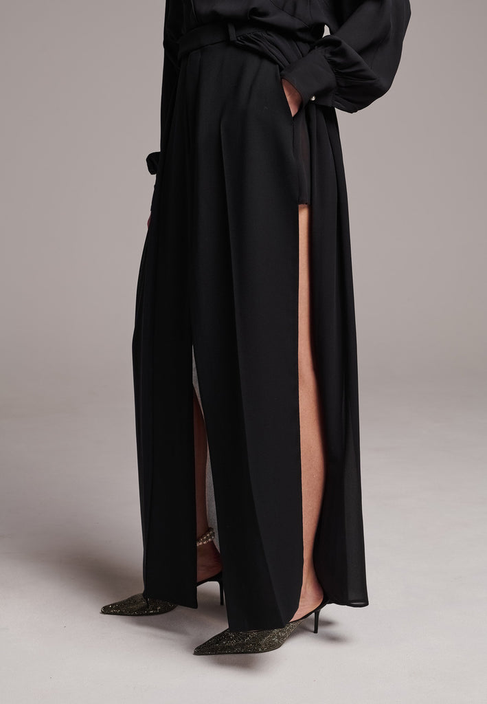A see-through skirt featuring a front slit and belt loops.