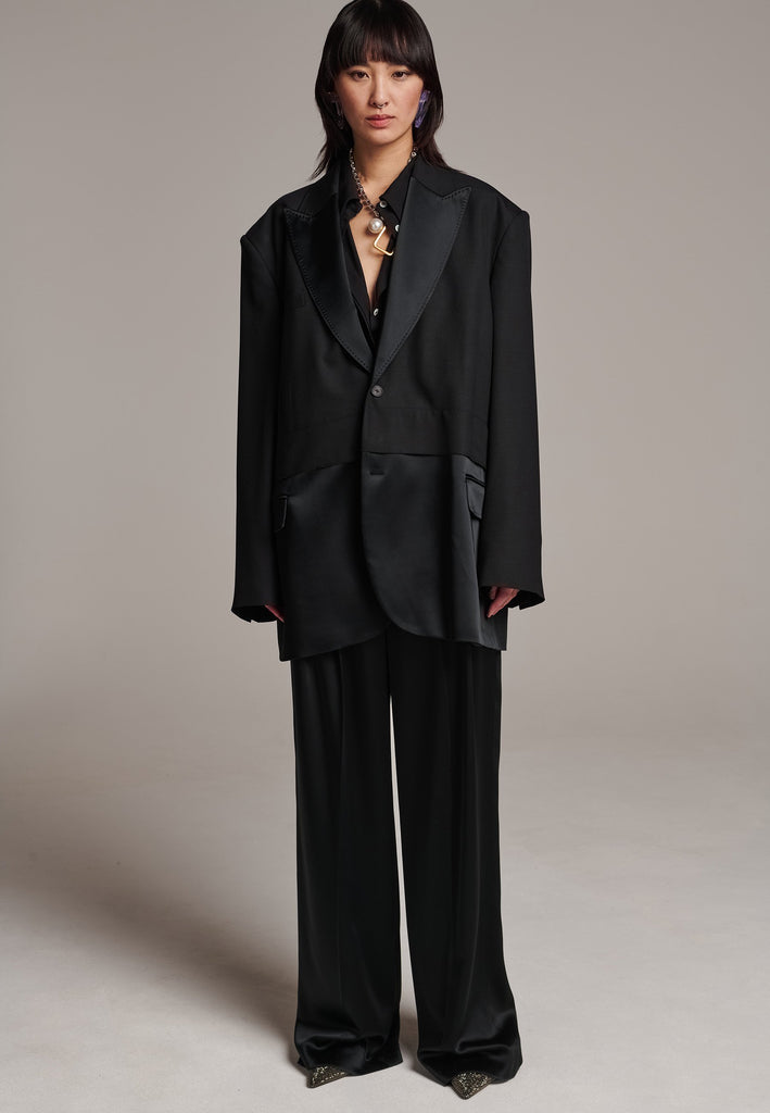 Creative Director Erik Frenken is a master of designing cool, oversized silhouettes, and this blazer is no exception. Precisely tailored with tuxedo-influenced satin lapels and needle point stitching. Full viscose satin lining, handy flap pockets. Horn square button fastenings. This piece will elevate every outfit to the next level, from jeans to dresses, and could easily become your everyday treasure.