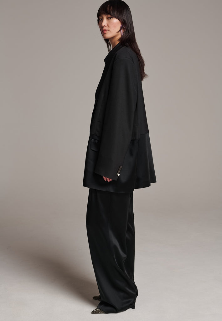 Creative Director Erik Frenken is a master of designing cool, oversized silhouettes, and this blazer is no exception. Precisely tailored with tuxedo-influenced satin lapels and needle point stitching. Full viscose satin lining, handy flap pockets. Horn square button fastenings. This piece will elevate every outfit to the next level, from jeans to dresses, and could easily become your everyday treasure.
