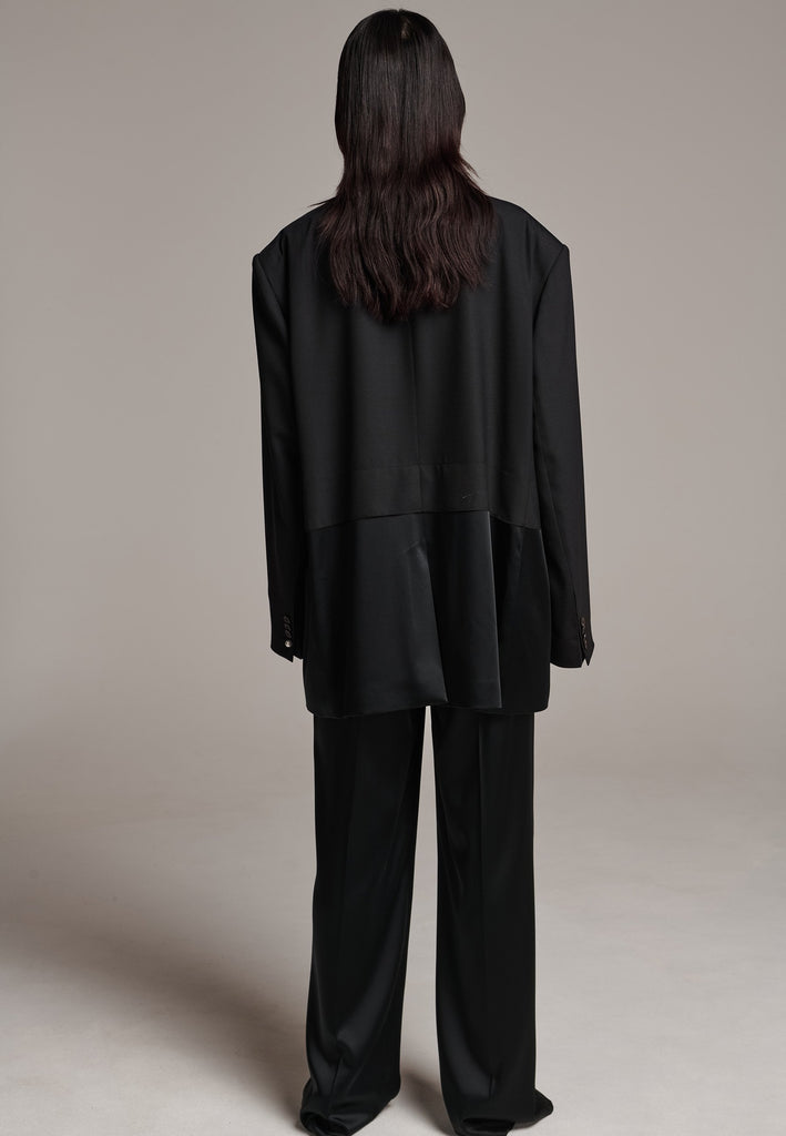 Creative Director Erik Frenken is a master of designing cool, oversized silhouettes, and this blazer is no exception. Precisely tailored with tuxedo-influenced satin lapels and needle point stitching. Full viscose satin lining, handy flap pockets. Horn square button fastenings. This piece will elevate every outfit to the next level, from jeans to dresses, and could easily become your everyday treasure.