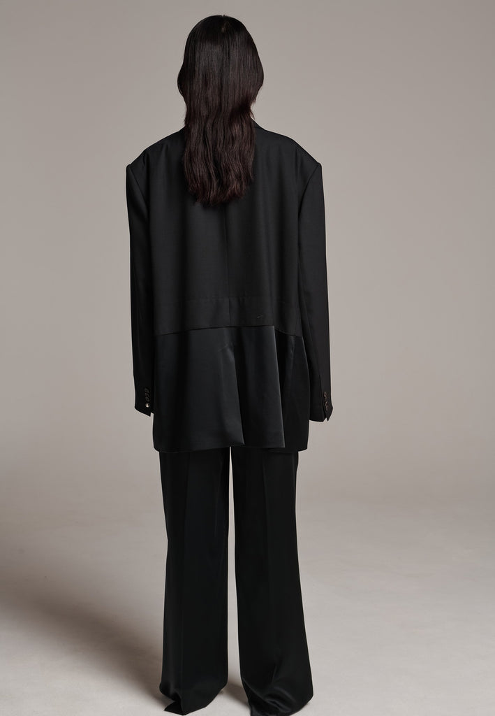 Creative Director Erik Frenken is a master of designing cool, oversized silhouettes, and this blazer is no exception. Precisely tailored with tuxedo-influenced satin lapels and needle point stitching. Full viscose satin lining, handy flap pockets. Horn square button fastenings. This piece will elevate every outfit to the next level, from jeans to dresses, and could easily become your everyday treasure.