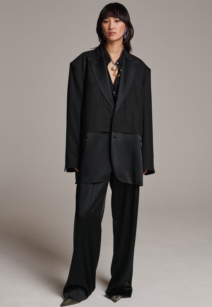 Creative Director Erik Frenken is a master of designing cool, oversized silhouettes, and this blazer is no exception. Precisely tailored with tuxedo-influenced satin lapels and needle point stitching. Full viscose satin lining, handy flap pockets. Horn square button fastenings. This piece will elevate every outfit to the next level, from jeans to dresses, and could easily become your everyday treasure.